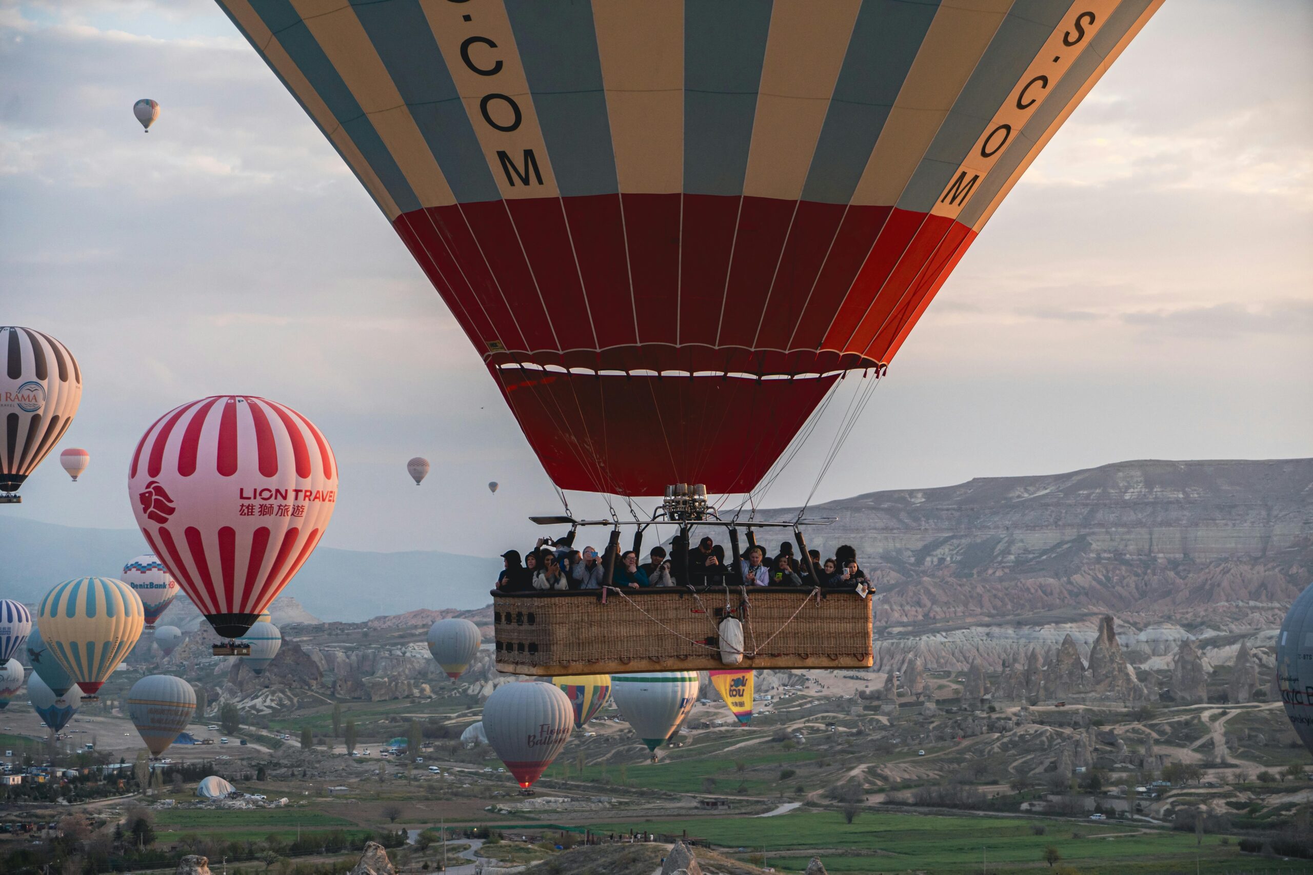 Hot air balloons soar over Cappadocia's unique landscapes during sunrise, offering breathtaking views.
