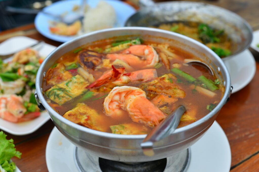 Close-up of a traditional Thai Tom Yum Goong soup with shrimp, known for its spicy flavors.