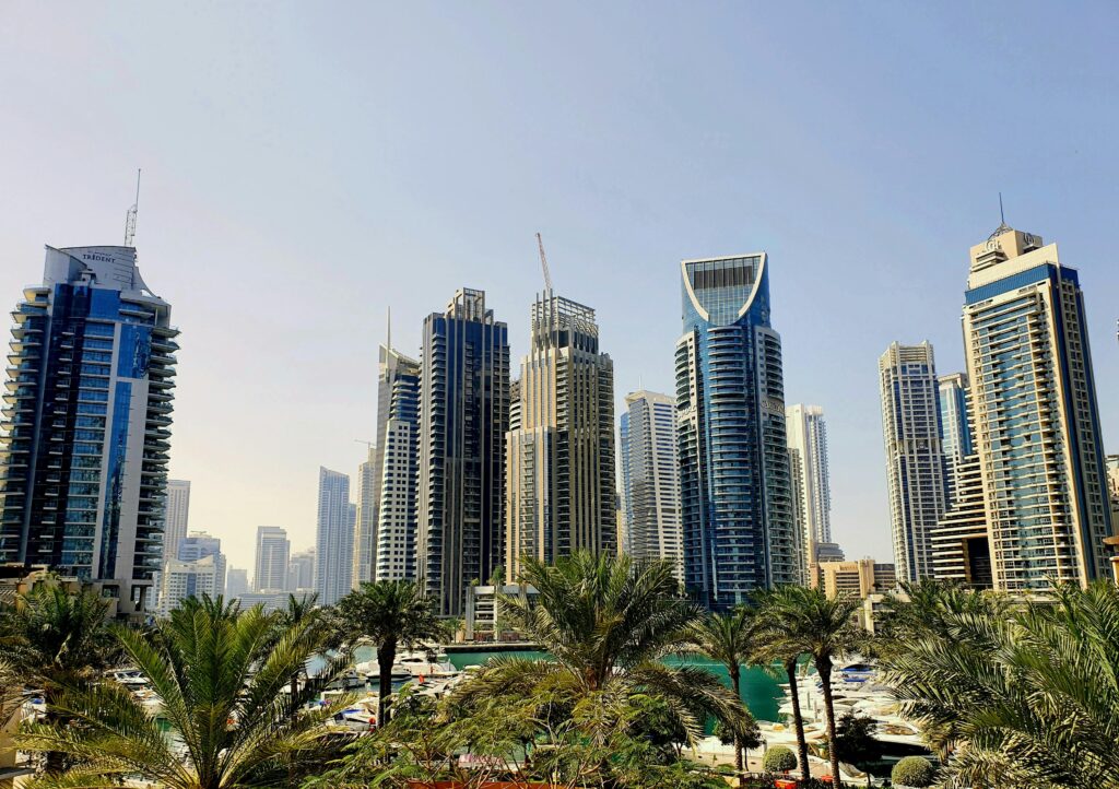 A vibrant view of Dubai's skyline featuring modern skyscrapers and palm trees during the day.