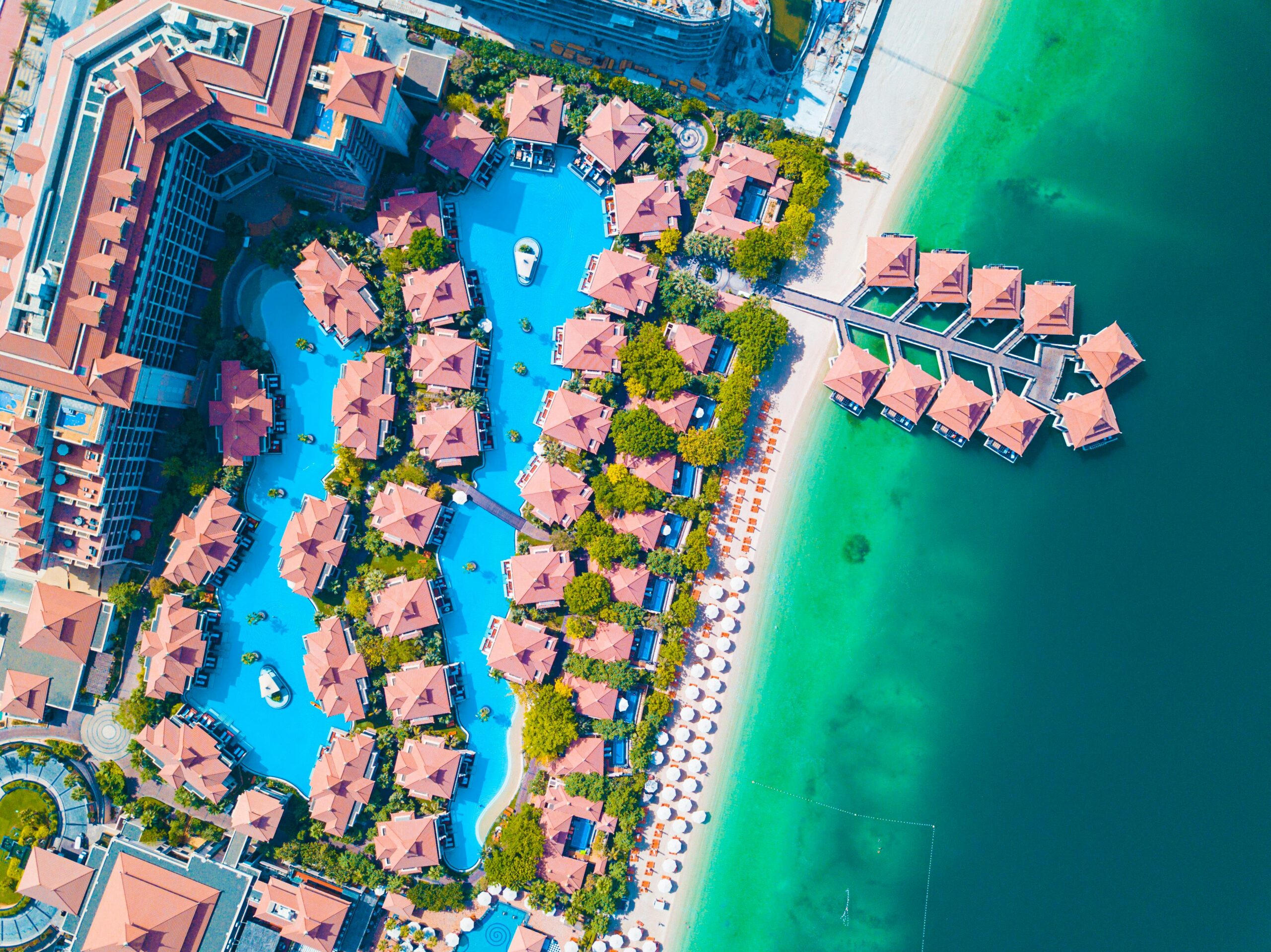 Stunning aerial shot of a luxurious Dubai beachfront resort with swimming pools.