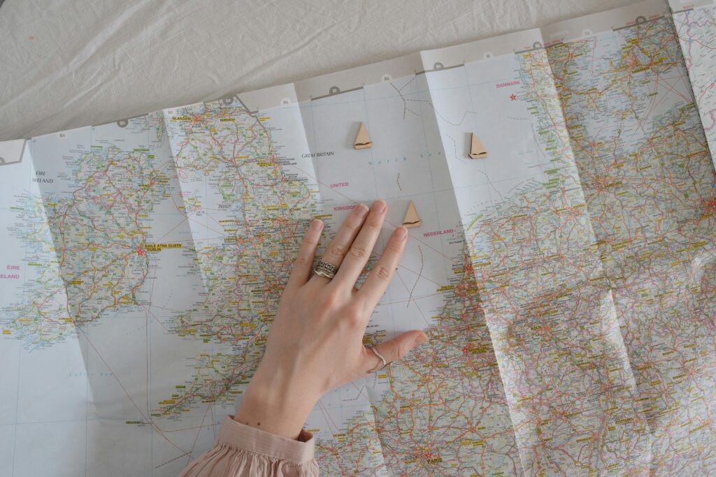 A hand on a map suggests travel and exploration, dream vacation spots.